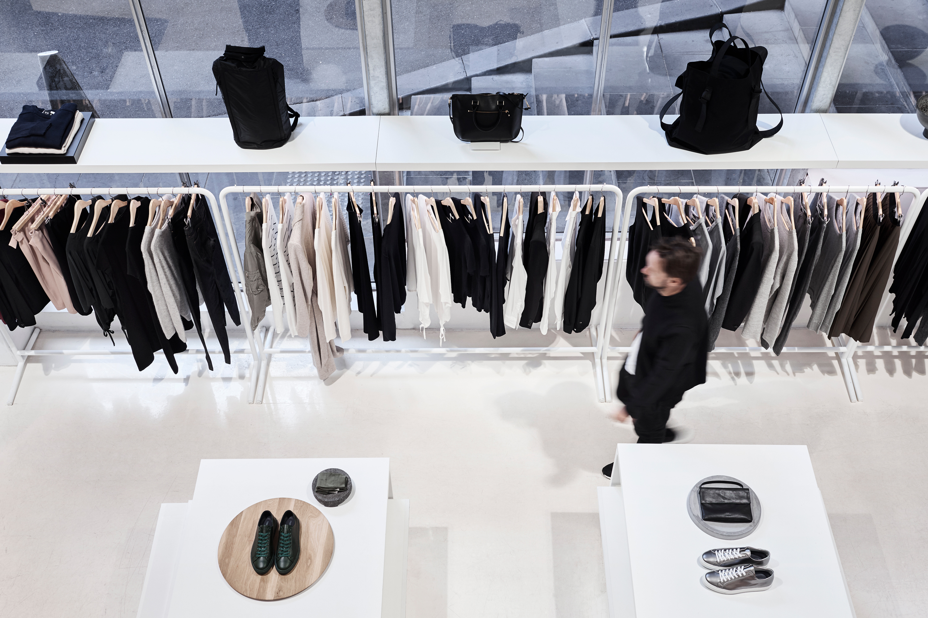 Interior of Swensk store with clothing racks, display tables, and a person walking through.