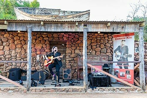 Guitarist performing on rustic outdoor stage at Finlay's