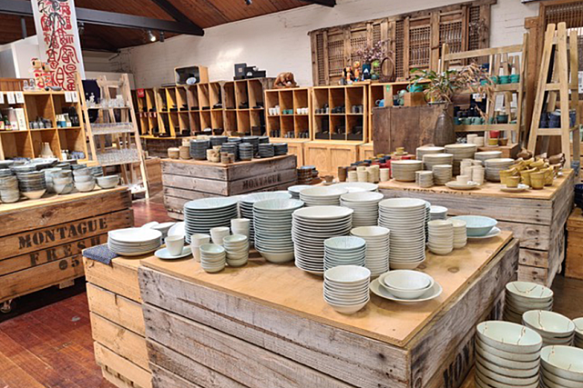 Made in Japan store interior with wooden shelves and tables displaying ceramic dishes, bowls, and cups.