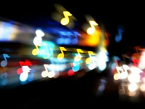 Blurred colourful lights with scattered yellow musical notes.